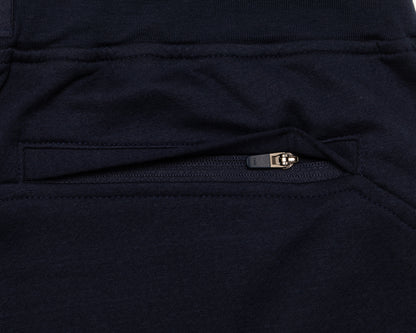 Close-up of a dark navy fabric garment showing a zippered pocket with a small metallic zipper pull.