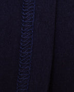 Close-up of the interior of navy knit fabric with flat-stitch hem running vertically down the center.