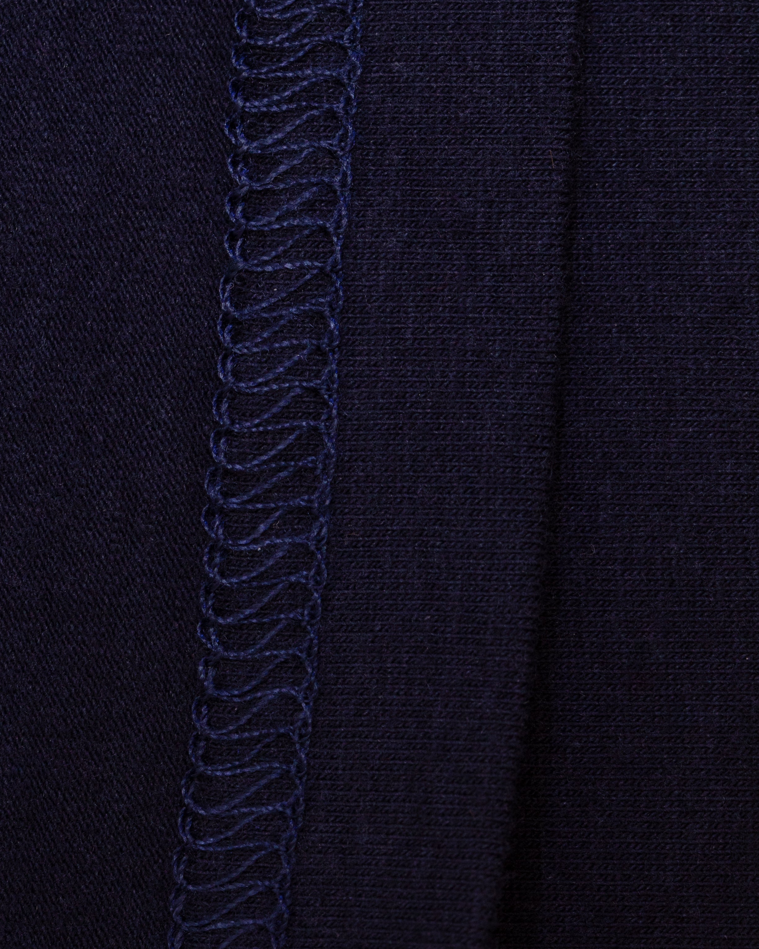 Close-up of the interior of navy knit fabric with flat-stitch hem running vertically down the center.