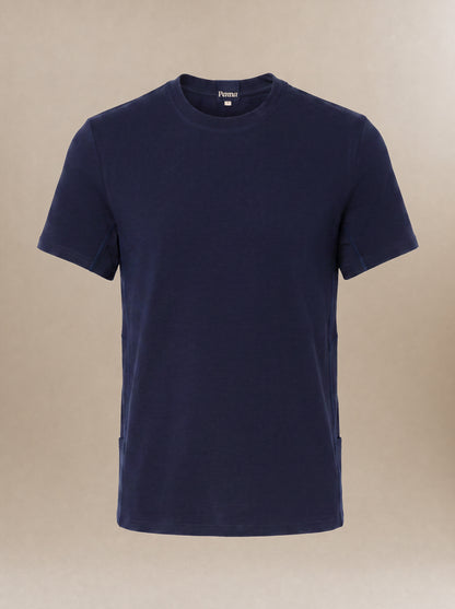 A navy blue short-sleeve crewneck subscrub shirt displayed on a neutral beige background.