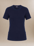 A navy blue short-sleeve crewneck underscrub t-shirt with a fitted silhouette and side pockets, displayed on a neutral beige background.